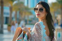 Middle eastern woman sunglasses bag accessories.