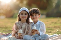 Middle eastern little boy and girl cream ice cream dessert.