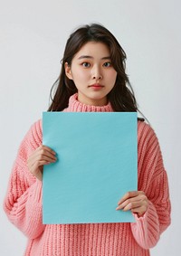 Holding a turquoise paper sheet photography sweater clothing.