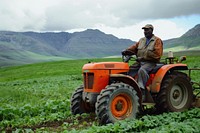 Black South African man farmer tractor field transportation.