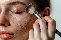 Photo of closeup woman face brush cosmetics makeup.