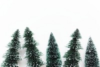 Miniature Christmas trees on a wooden surface. One tree is taller, both are green with a snowy effect. Simple holiday decor with Christmas trees. Christmas decorations elements with copy space.