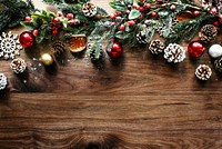 Festive Christmas decorations with pinecones, red ornaments, and greenery on a wooden table. Holiday with pinecones and ornaments for a Christmas theme. Wood texture background. Christmas background.