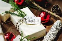 Festive Christmas scene with wrapped gifts, red ornaments, and pine branches. Christmas gifts and ornaments create a cozy holiday atmosphere. Holiday and Christmas present on table.