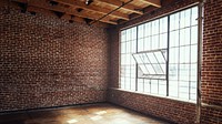 Spacious loft with exposed brick walls and large windows. Sunlit loft, perfect for creative spaces. Brick and windows create an airy, open loft atmosphere. Urban loft style home interior with window.