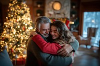 Teen daughter hugging her mother and father in the living room with joy christmas holiday tree.