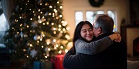 Teen daughter hugging her mother and father in the living room with joy christmas holiday lights.