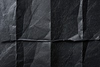 Black folded paper texture background clothing wrinkled.