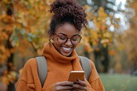 Woman looking at the phone background person autumn.