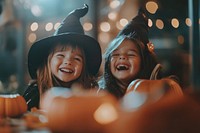 Two happy little latin kids in witch costumes halloween pumpkin celebration.