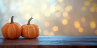 Pumpkins on a wooden table background orange bokeh.