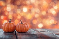 Pumpkins on a wooden table background orange bokeh.