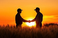 Two farmers shake hands sunset field collaboration.