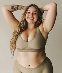 A happy woman in modest intimate yoga apparel positivity tattoo smile.