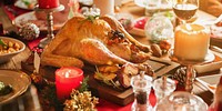 Festive holiday dinner with a roasted turkey centerpiece. Candles and decorations create a warm, inviting atmosphere. Perfect for a holiday feast with family. Christmas dinner with turkey.