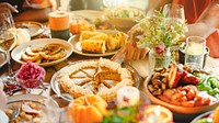 Festive autumn feast with pumpkin pie, corn, and candles. A warm, inviting table setting with seasonal dishes and vibrant fall colors, perfect for a cozy gathering. Thanksgiving food on dinner table.