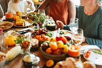 A diverse group enjoying a festive meal with colorful dishes, fresh vegetables, and drinks. The table is filled with vibrant food and cheerful conversation. Diverse people enjoying festive meal.