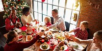 A diverse family enjoys a festive Christmas dinner. Christmas tree, holiday meal, and family gathering create a warm, joyful Christmas atmosphere. family in Christmas gathering celebrating and eating.