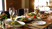 Elegant dining setup with wine glasses, plates, and gourmet dishes. Wine and gourmet meals create a luxurious dining experience. Elegant table setting. Table set dinner in the restaurant