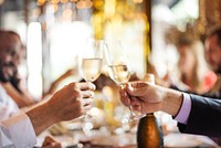 Hands clinking champagne glasses in a celebratory toast. Festive atmosphere with blurred lights. Cheers to celebration, joy, and togetherness. People toasting and celebrating at dinner.