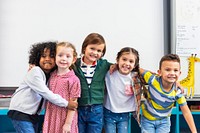 Diverse group of happy children smiling, hugging, and posing together in a classroom. Kids, friendship, and joy are captured in classroom. Happy kids embrace in front of whiteboard in classroom.