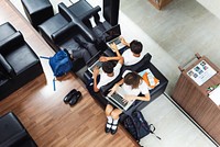 Three students using laptops in a lounge area. Students focused on laptops, sitting together. Casual setting with students engaged in technology. Digital divece for education and knowledge. 