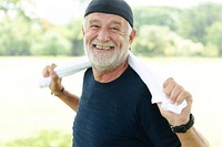 Happy senior man outdoors, smiling with a towel around his neck. Happy elderly man enjoying nature. Elderly man in casual attire, cheerful and relaxed. Happy senior man smiling and exercising.