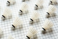 Badminton background. Shuttlecocks arranged on a grid pattern. White shuttlecocks on a grid. Sports equipment for badminton. Shuttlecocks on a grid background. Badminton background.