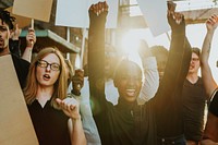 Group of happy diverse people at a protest, holding signs. Diverse people focused on protesting holding signs. Diverse men and women protesting outdoor holding signs. Diverse people protesting outdoor