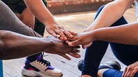 Diverse group of hands stacked in unity. Teamwork and collaboration. Close-up of hands showing support and cooperation. Unity in diversity. Diverse people staching hands together as team at gym.