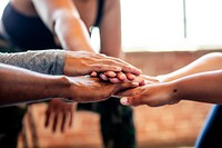 Diverse group of people, putting hands together in a team huddle. Diverse group, teamwork, and unity in fitness. Diverse group bonding. Exercise for better health. Team stacking hands in huddle.