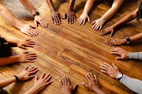 Diverse hands form a circle on a wooden floor. Unity, teamwork, and diversity. Hands circle team unity. Diverse people hands together partnership on wooden floor. Diverse ethnics hands circle together