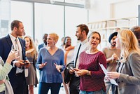 A diverse group of professionals, including men and women of various ethnicities, engage in lively conversation at a networking event, showcasing collaboration and connection.