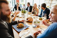 A diverse group of people enjoying a meal together at a stylish table share laughter and fine dining, celebrating friendship and good food. Business community event