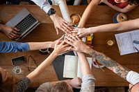 Diverse hands join in teamwork over wooden table, startup business team meeting. Teamwork and collaboration with diverse hands. Diverse group of business people team join hands for teamwork