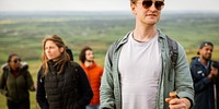 Group of hikers outdoors, diverse group enjoying nature. Young adults hiking, exploring, wearing casual gear. Scenic landscape, adventure, exploration, nature. Happy friends hiking in British nature.