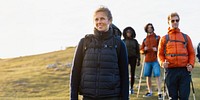 Group of diverse hikers outdoors. Diverse men and women hiking. Outdoor adventure with diverse group. Hiking gear on diverse hikers. Sunny day for hiking. Diverse hiking friends standing on hill