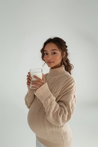 Mixed race pregnant woman sweater milk holding.