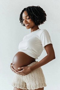 A happy black pregnant woman with her belly photo background knitted.