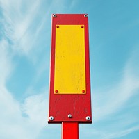 A red and yellow symbol sign standy sky minimalist outdoors.