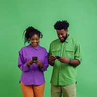 An isolated black man wearing green shirt with a black woman wearing purple shirt playing his phone with smile photography background clothing.