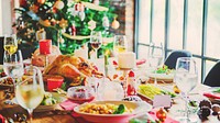 Festive holiday table with a Christmas tree, decorated with candles, wine glasses, and a turkey. Holiday feast with a Christmas tree and festive decor. Festive Christmas dinner in rustic home.