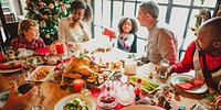 Festive family dinner with diverse group enjoying holiday meal. Christmas tree, turkey, and decorations create a joyful atmosphere around the table. Diverse family at Christmas dinner with turkey.