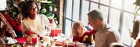 Festive family gathering around a Christmas table. Joyful celebration with diverse family. Christmas tree, gifts, and laughter. Warm holiday atmosphere with family. Christmas family dinner table.