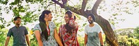 Group of Indian friends laughing outdoors. Diverse group enjoying nature. Friends smiling under trees. Happy group, diverse backgrounds, enjoying time together. Young Indian friends at the park.