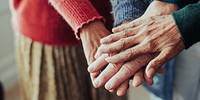 Close-up of elderly hands gently holding each other. Elderly hands showing warmth and compassion in a tender moment. Old people stacking hands in the middle together.