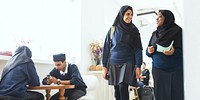 Group of Muslim students in a Muslim school uniforms, wearing traditional attire. Muslim girl students in hijabs in school. Diverse multiracial school atmostphere.