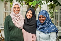 Three muslim women wearing hijabs smiling outdoors. Diverse group of women in hijabs. Women in hijabs enjoying time together. Hijabs, smiles, diversity. Happy muslim teenage girls standing together.