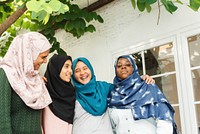 Group of diverse Muslim women in hijabs smiling and embracing. Muslim women in hijabs, diverse ethnicities, smiling together. Muslim young women hanging out together.