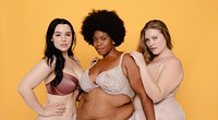 Three women in lingerie against a yellow background, showcasing body positivity and diversity. Embracing confidence and diversity in lingerie. Diverse women in lingerie, body positivity.